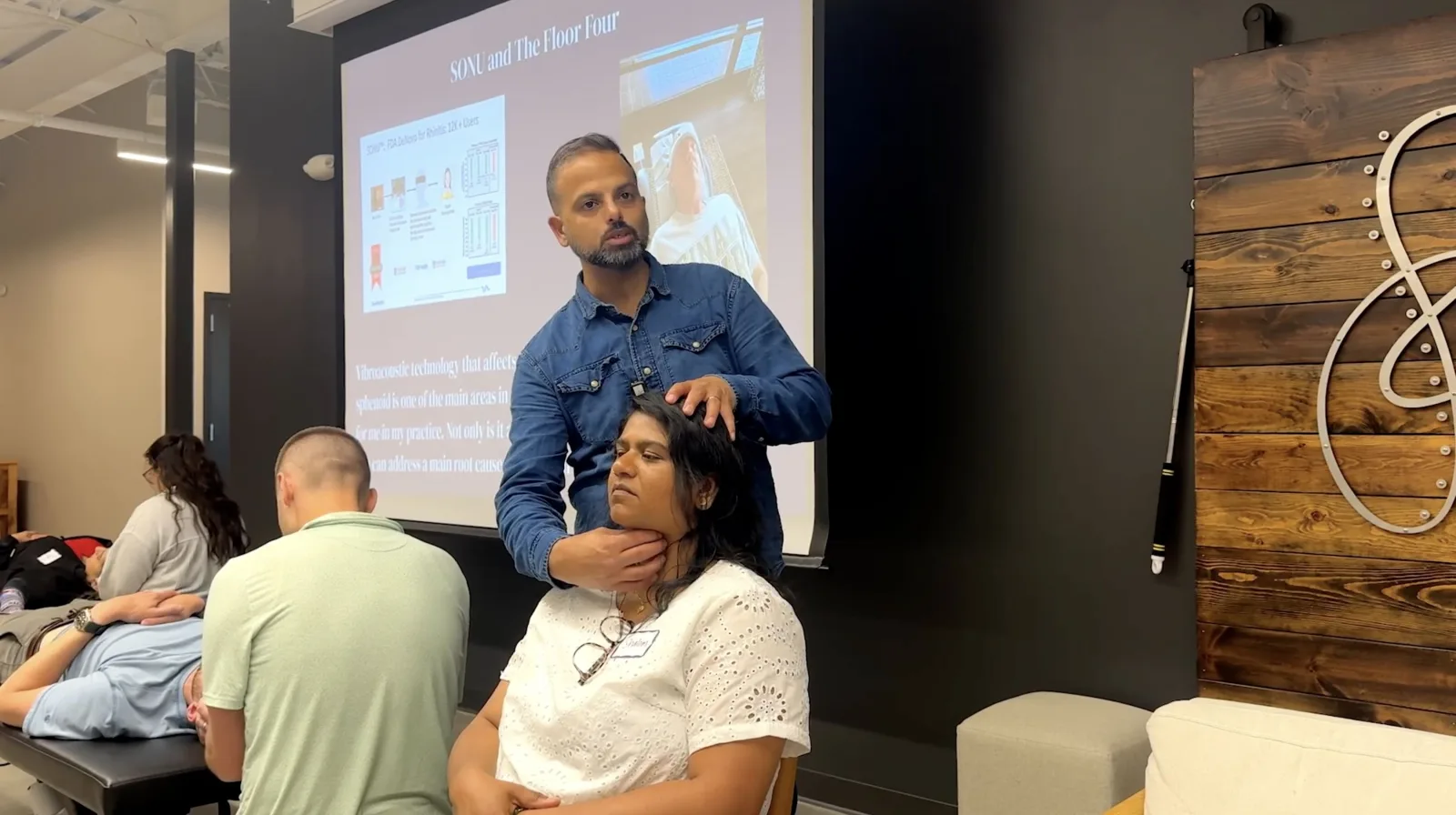 Dr. Neel Bulchandani demonstrating a seated thyroid release during the Floor Four training